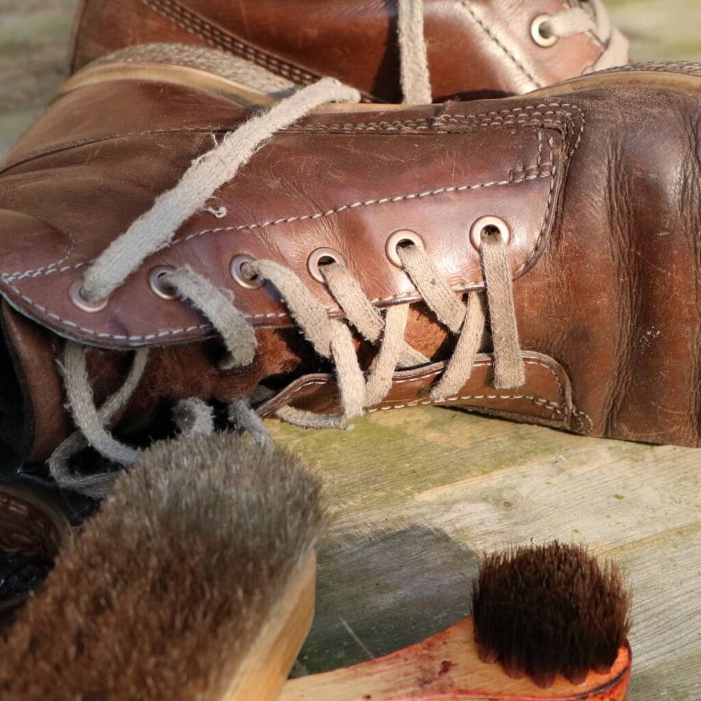 Close-up of polished black leather dress shoes on a wooden surface.